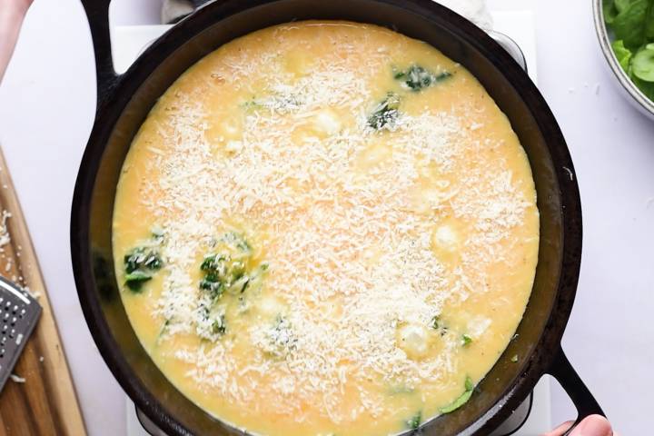 Spinach frittata with parmesan cheese on top before being cooked.