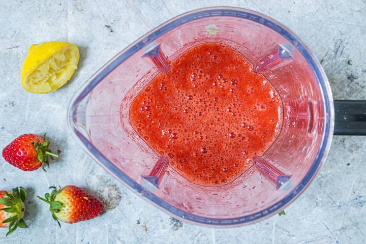 Strawberries and honey blended in a blender.