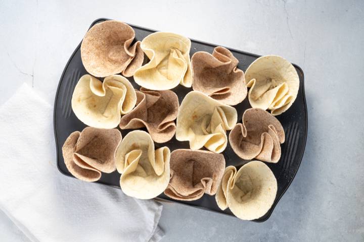 Tortillas pressed into a muffin tin. 