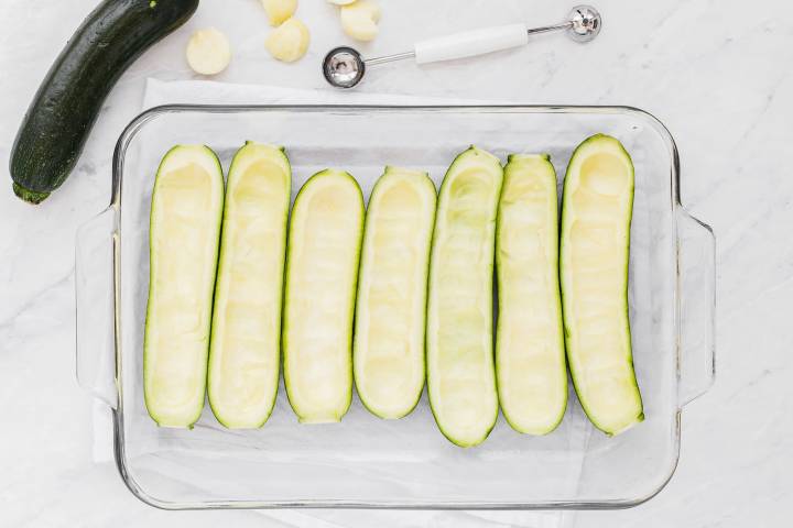Hollowed out zucchini in a bakin dish.