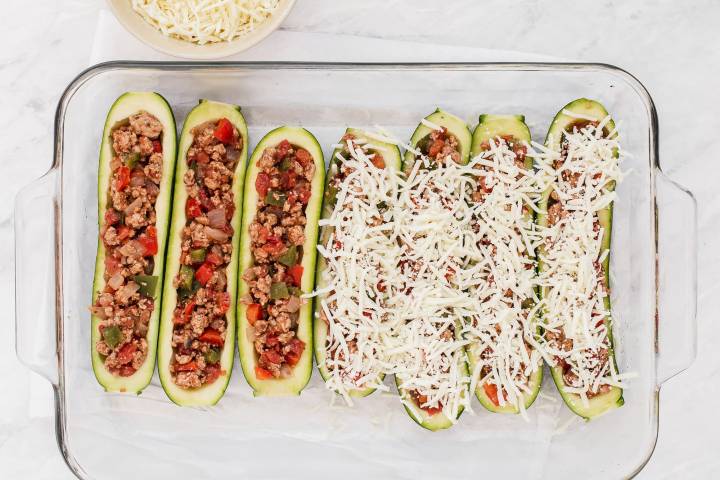 Zucchini boats filled with ground turkey, vegetables, and shredded cheese.