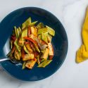 Sheet pan asian tofu with vegetables in a blue bowl with a yellow napkin.