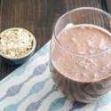Chocolate oatmeal smoothie in a glass mason jar with a banana garnish.