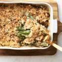 Green bean casserole in a dish, being served with a spoon.