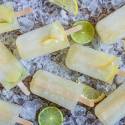 Lemon lime popsicles with fresh lemon and lime slices on a bed of ice.