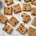 No Bake Oatmeal bars with chocolate chips, chia seeds, flaxseed, and coconut on parchment paper.