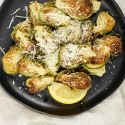 Parmesan Brussels Sprouts with lemon on a plate with a linen napkin.