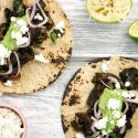 Portobello mushroom tacos with avocado salsa on corn tortillas.