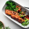 Teriyaki salmon baked in the oven and served with green onions, sesame seeds, and broccoli on the side.