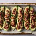 Baked Tex-Mex stuffed zucchini with cheese, tomato sauce, and cilantro on a parchment-lined baking tray.