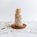 Zucchini bread overnight oatmeal in a glass jar with cinnamon, rolled oats, almond butter, and shredded zucchini.