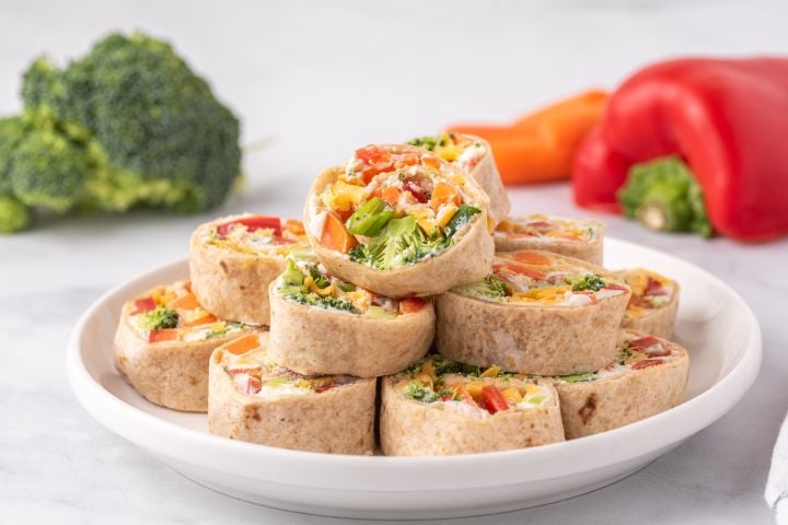 Cream cheese pinwheel with chopped vegetables and ranch seasoning cut into slices on a plate.