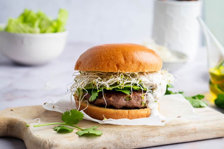 Jalapeno cheddar burgers with lettuce, tomato, and onion served on a hamburger bun, 