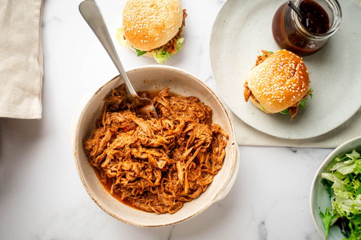 Slow cooker spicy pulled pork with shredded pork tenderloin in spicy barbecue sauce in a bowl.