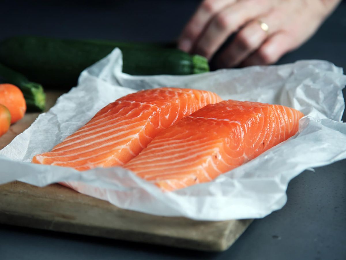 Salmon meat on brown chopping board