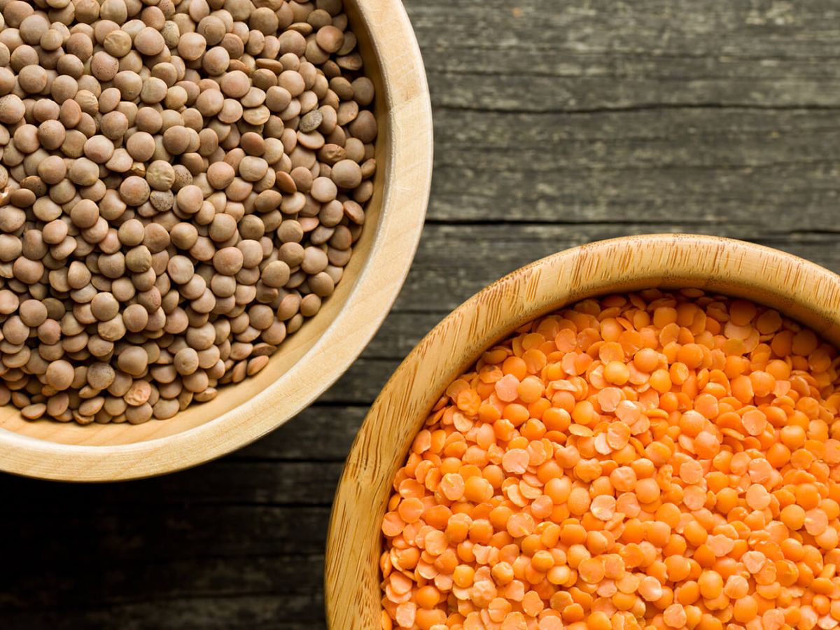 Two bowls with peeled and unpeeled red lentils