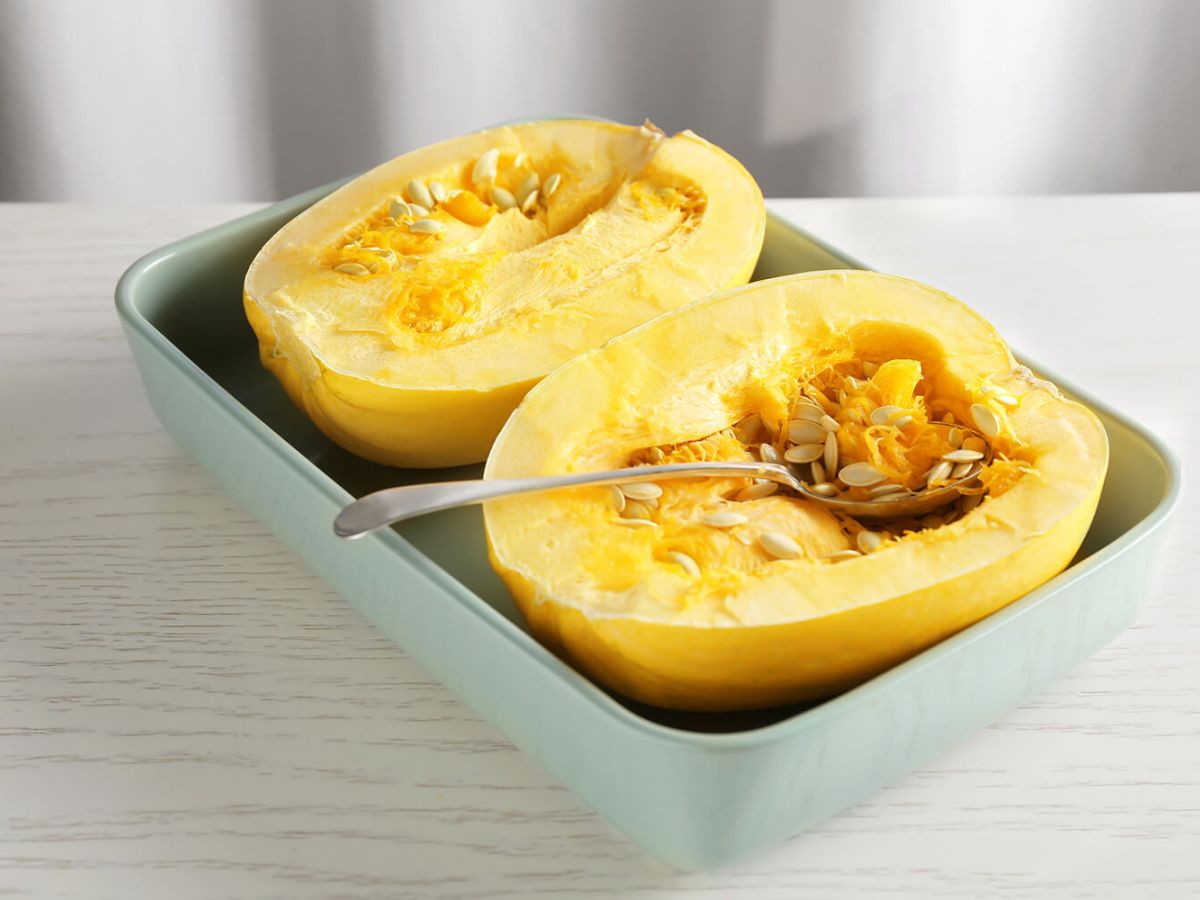 Spaghetti squash cut in half on a blue plate