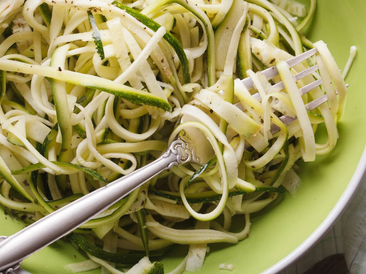 Zucchini Noodles on a green bowl with a fork