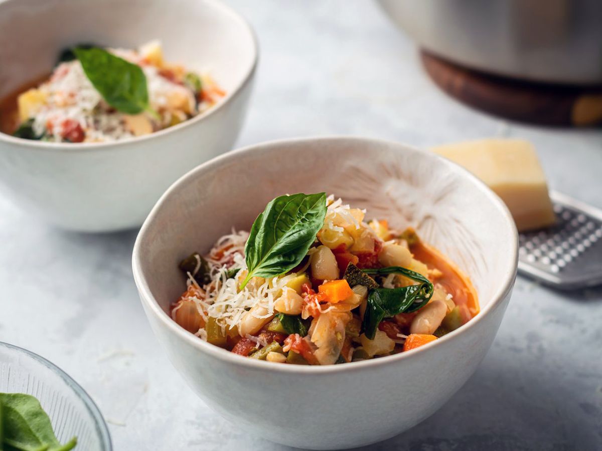 A Delicious Italian Vegetable and Bean Soup in a White Bowl Garnished with Basil